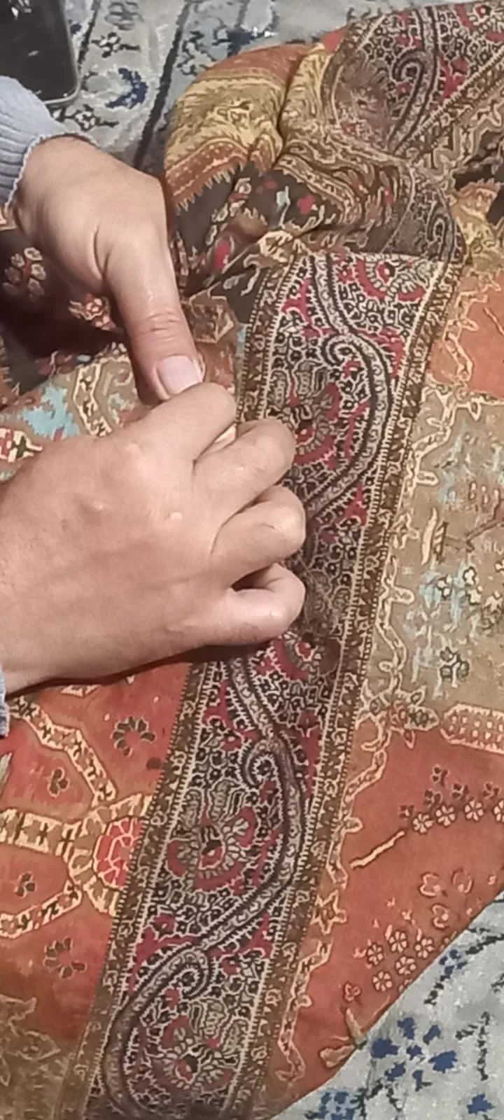 Manos sosteniendo un textil terminado
